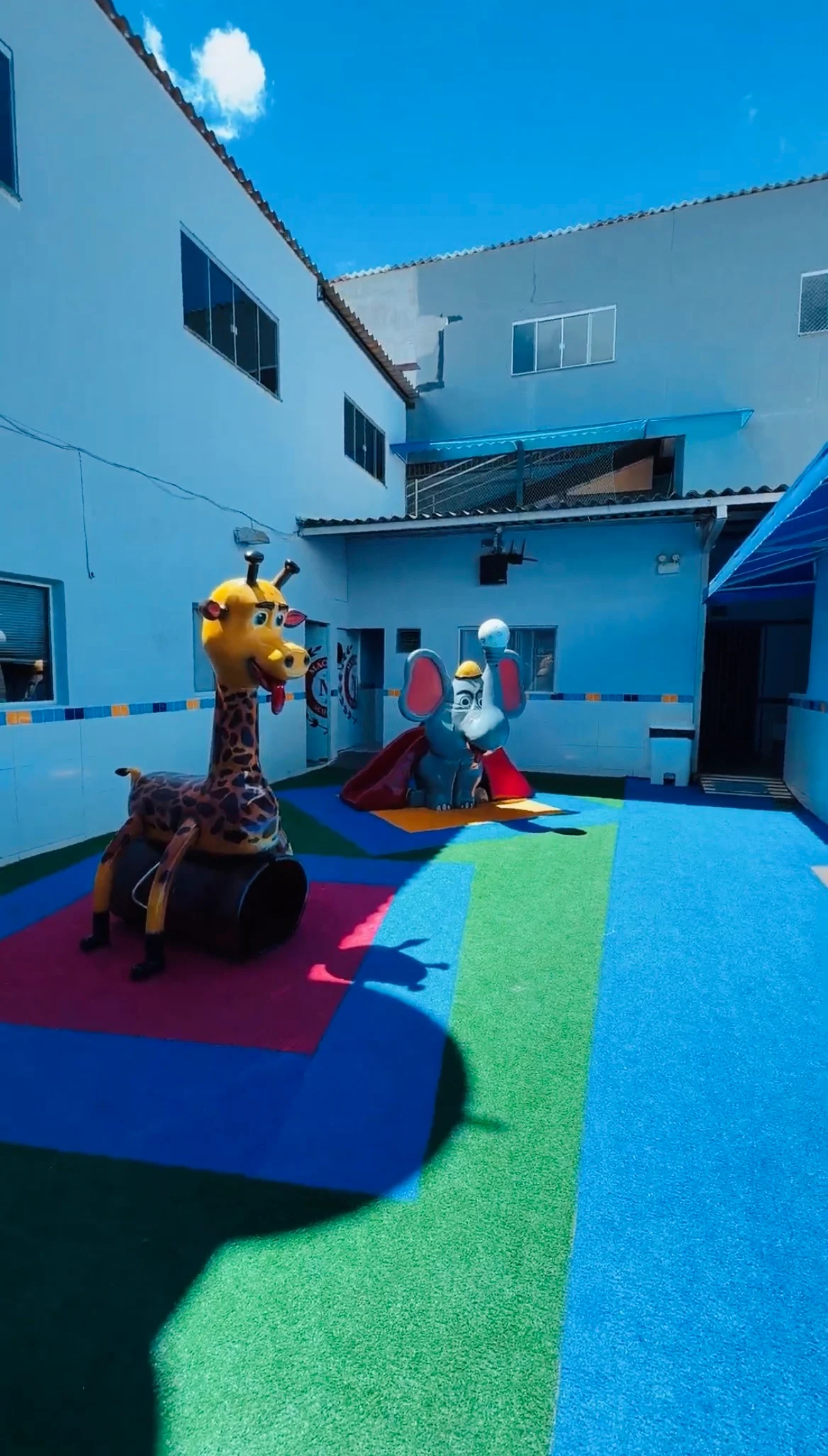 Playground externo com piso colorido na Mackedu School